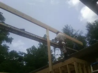 Carpenter setting a ridge beam over a new addition frame — Ice Dam Removal by Roofing Brothers in Park Hall
