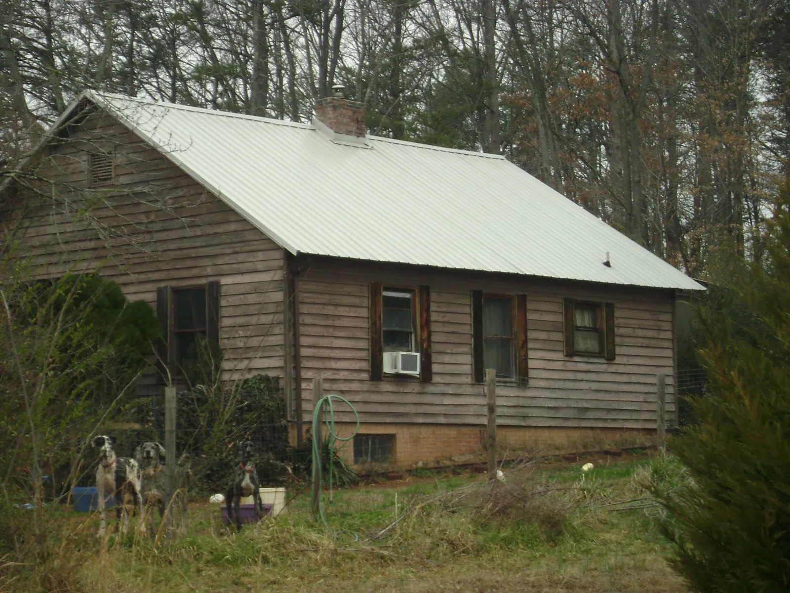 White metal roof on an old wood sided farmhouse, from a Metal Roof Installation job in Park Hall